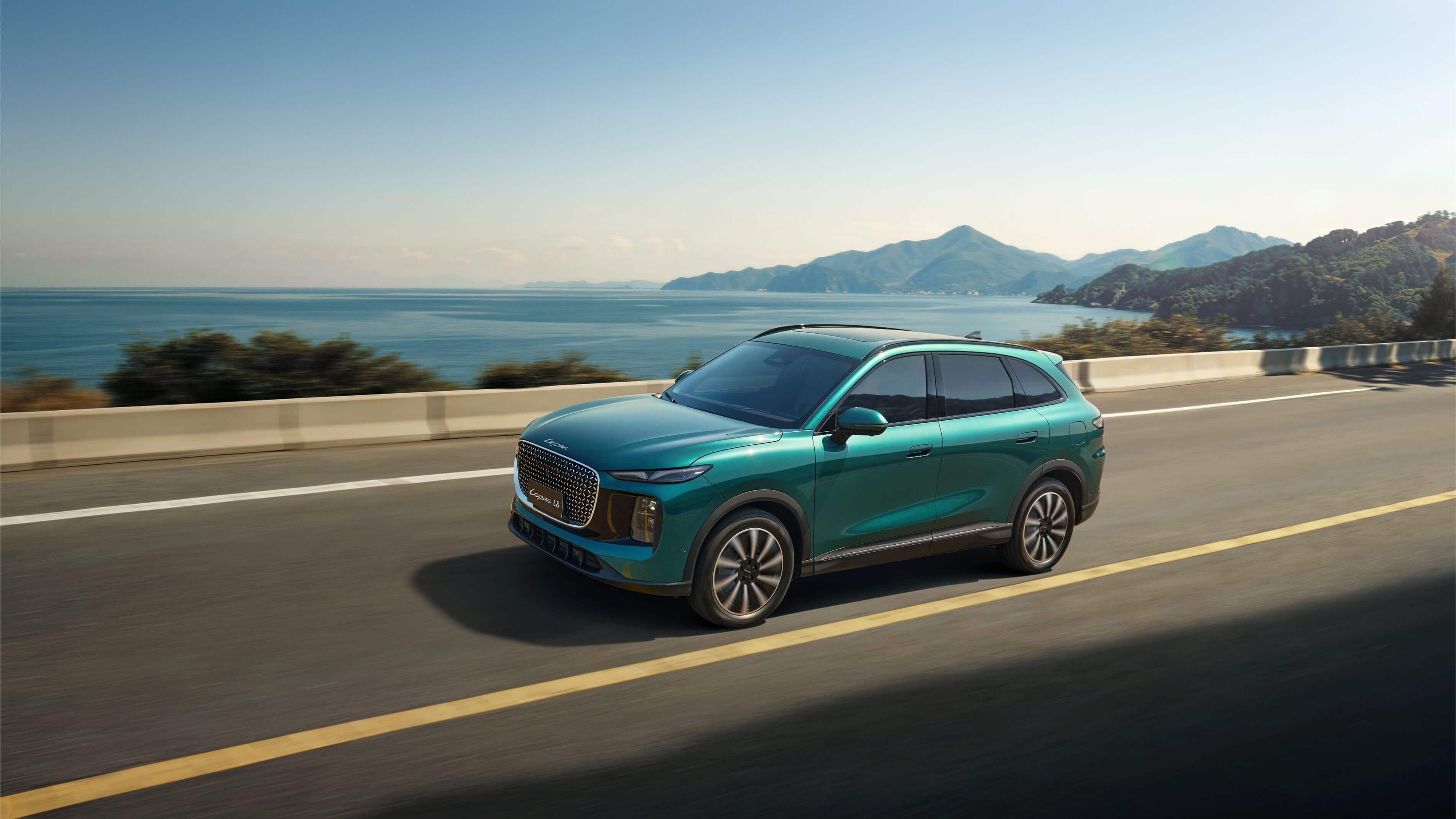 Teal Lepas L8 driving on a coastal highway beside the sea