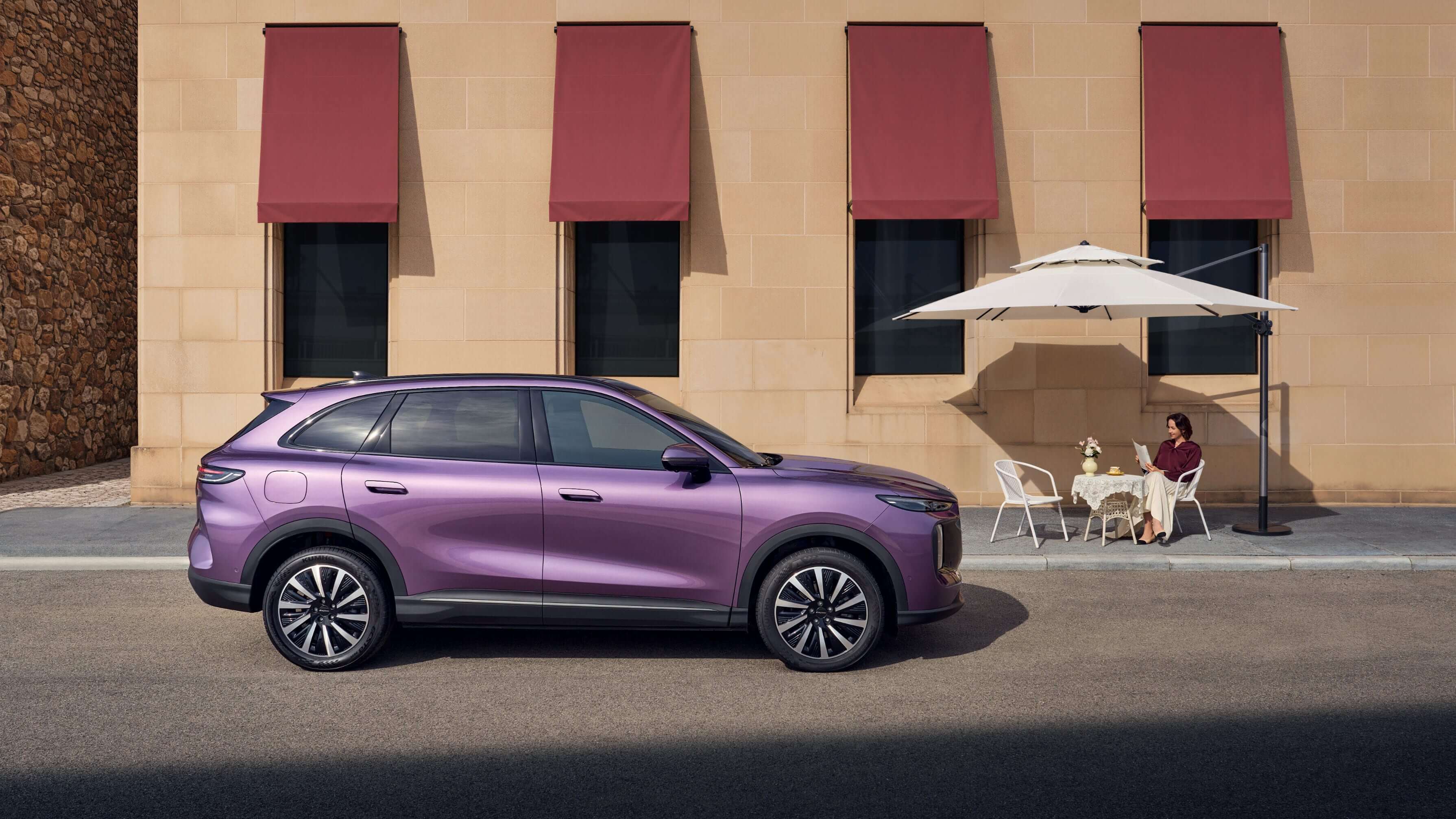 Side profile of a purple Lepas L8 parked beside a café terrace